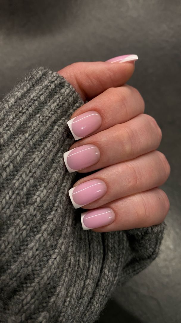 Dłoń z delikatnym różowym frenchem na paznokciach o kwadratowym kształcie, białe końcówki.
