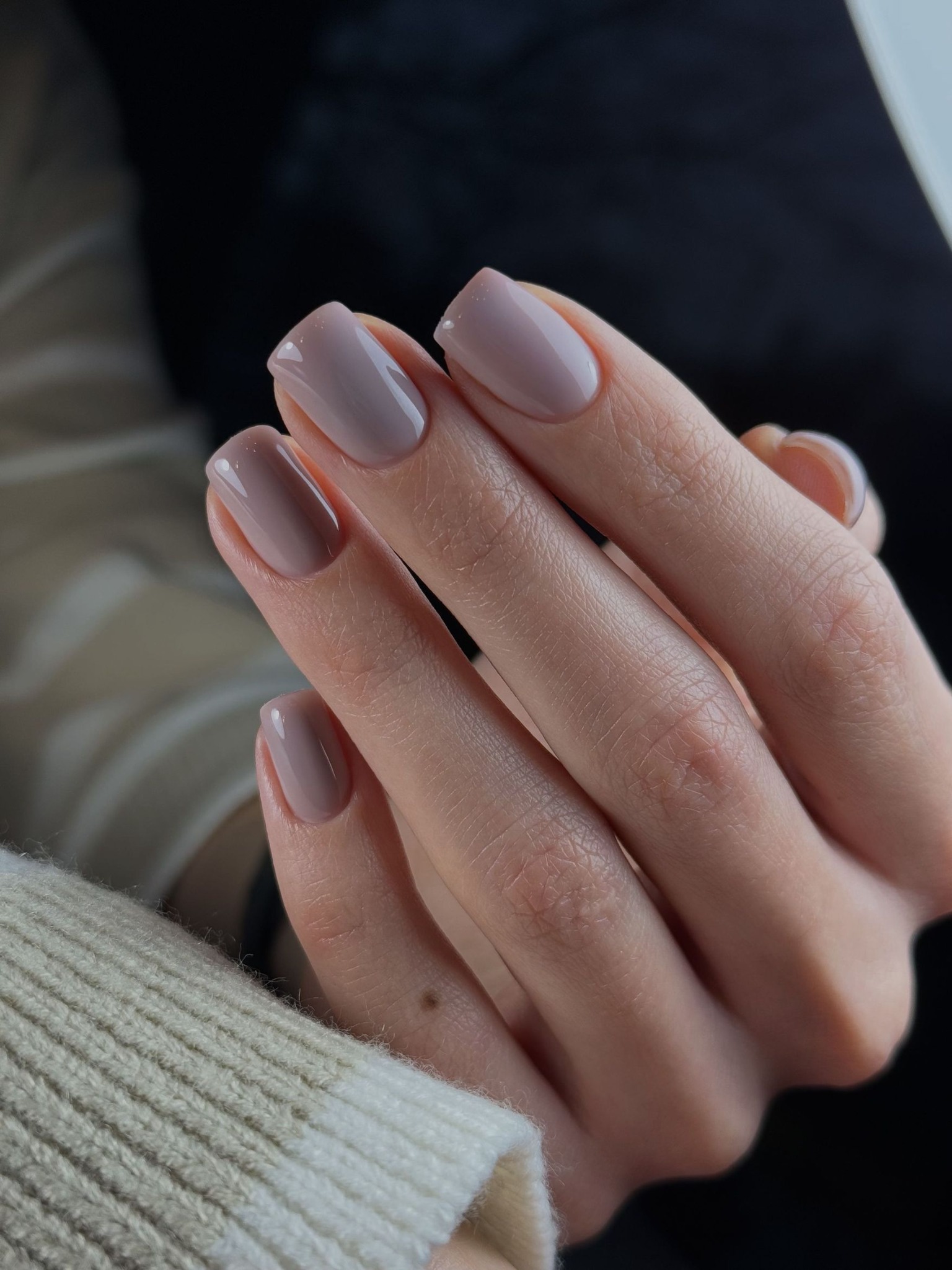 Chłodny nude taupe manicure na krótkich paznokciach o kwadratowym kształcie.