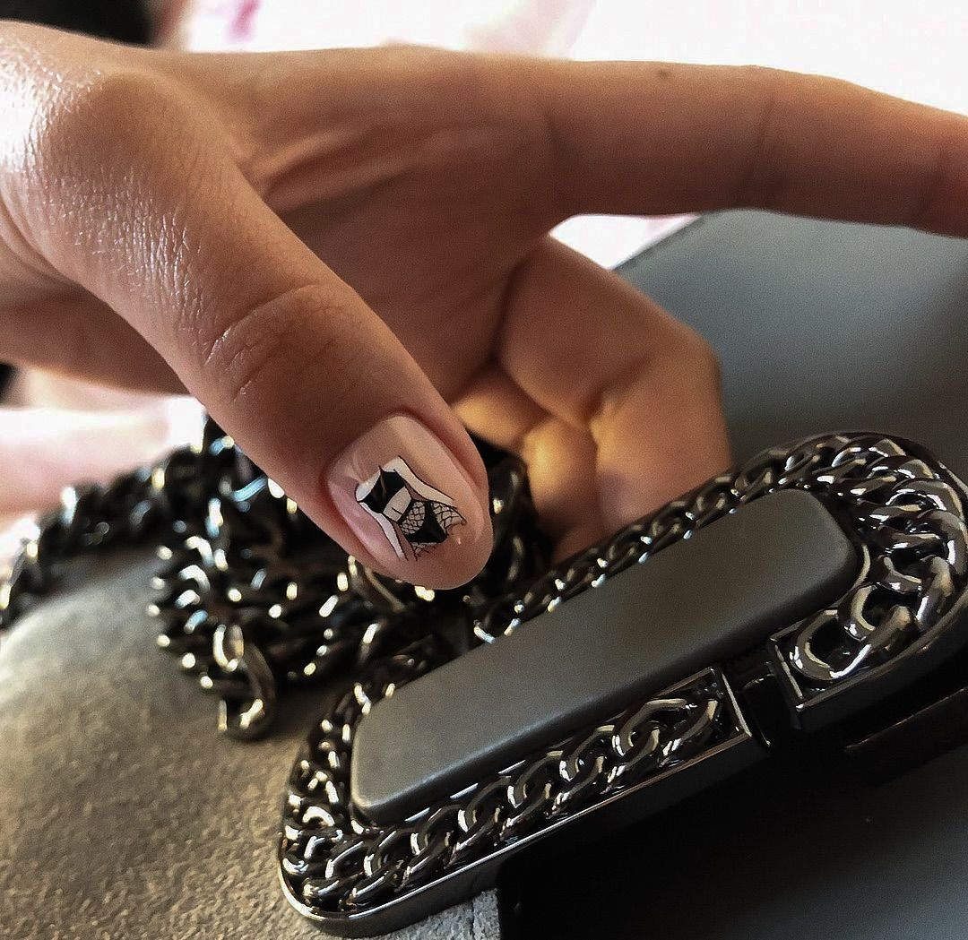 Nude manicure z minimalistycznym graficznym akcentem na jednym paznokciu.